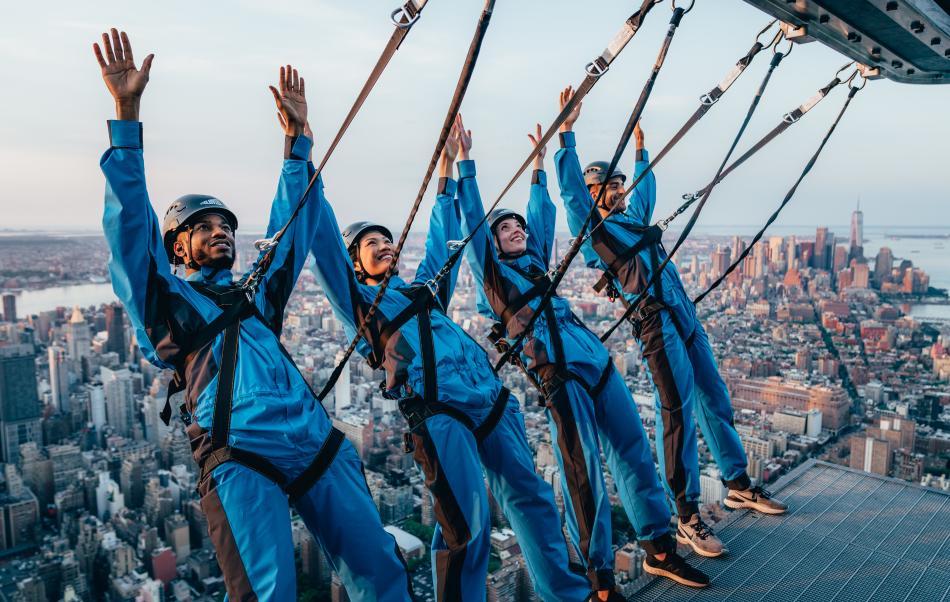 Group of four people climbing the side of edge. 